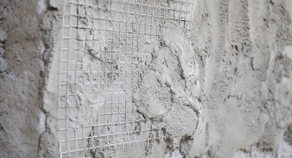 Imagem mostrando a aplicação da tela residência em um quintal de uma casa com tijolos marrons e com janelas de vidros compridas